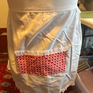 Vintage white cotton apron with a red heart and white pocket with lace-